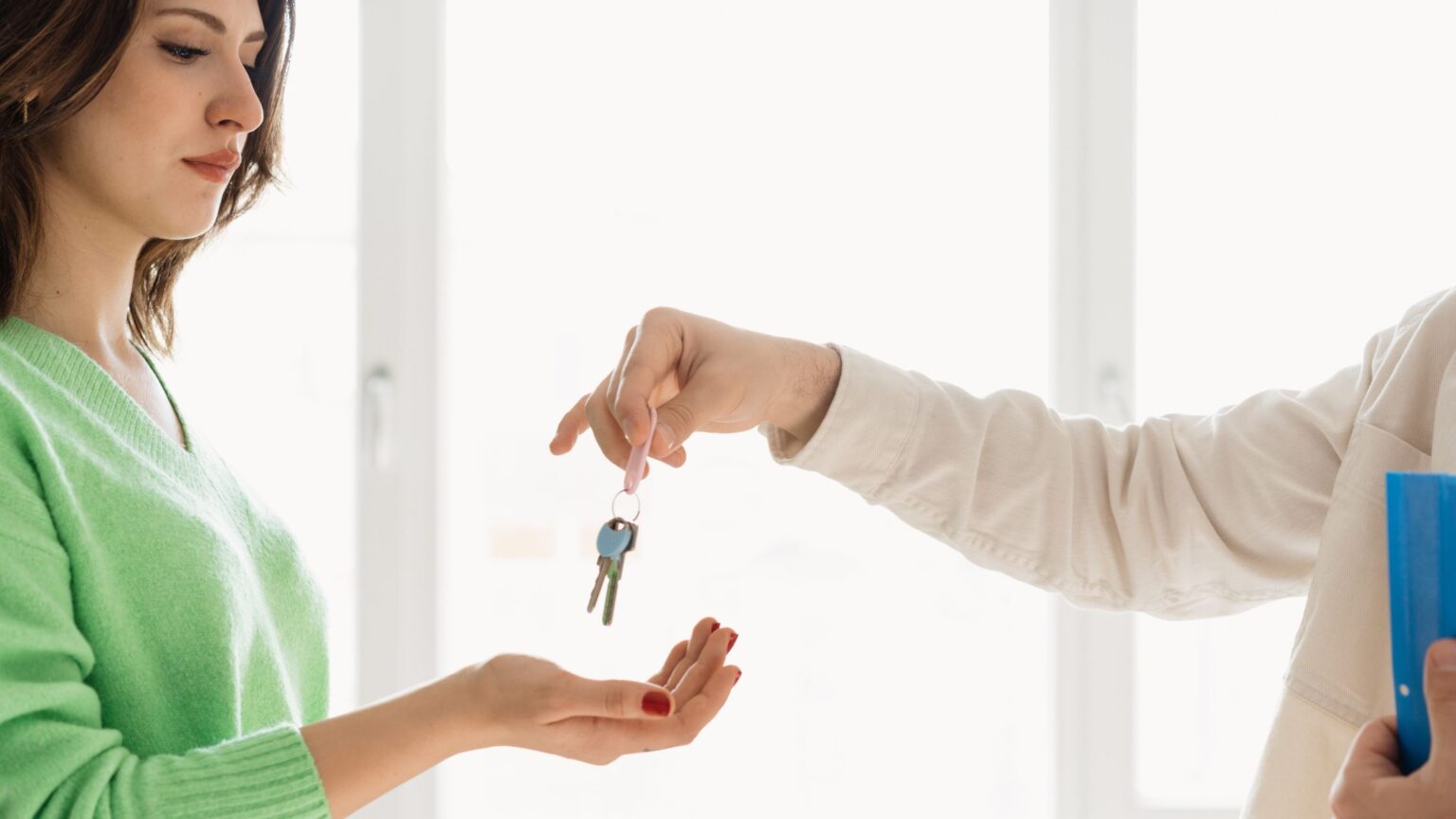Woman receiving the keys to her new home from a real estate agent